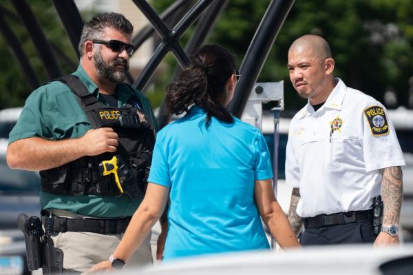 Forest Park Deputy Chief Christopher Chin, right, stands outside the Forest Park Blue Line train station 