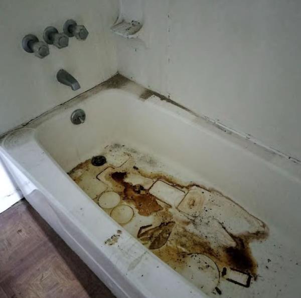 Extensive water damage inside the tub of the apartment.