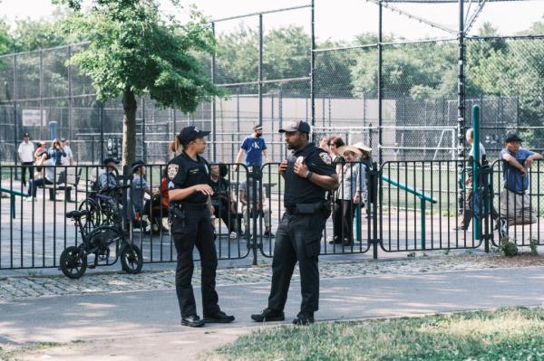 Two NYPD officers patrolling near Silent Springs Playground in Kissena Park, Queens following a reported crime incident.
