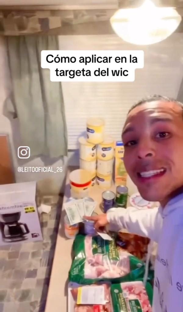 A man smiling at the camera, showing off the groceries he and his wife got for free with a WIC card
