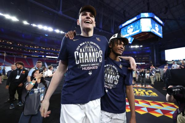Do<em></em>novan Clingan and Stephon Castle of the Co<em></em>nnecticut Huskies celebrating their NCAA Men's Basketball Tournament victory over the Purdue Boilermakers in a stadium