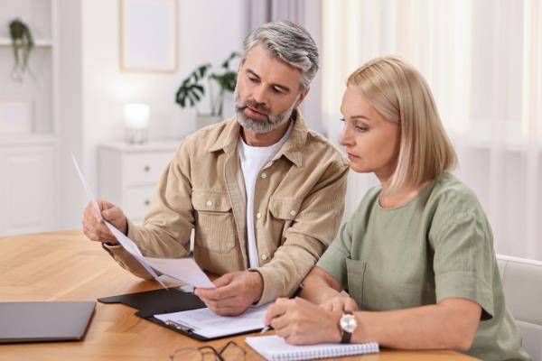 A man and woman planning their pension budget at a table indoors