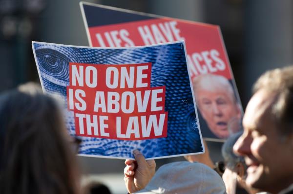 Protesters with anti-Trump signs.