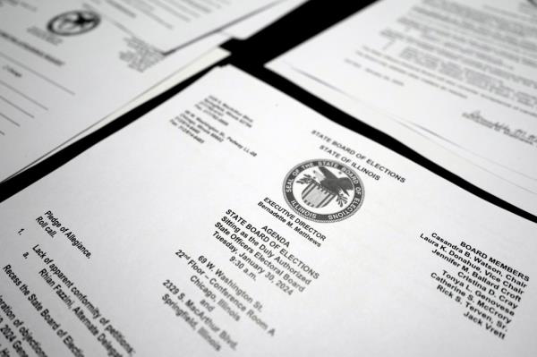 Papers with information on a table during an election board meeting.