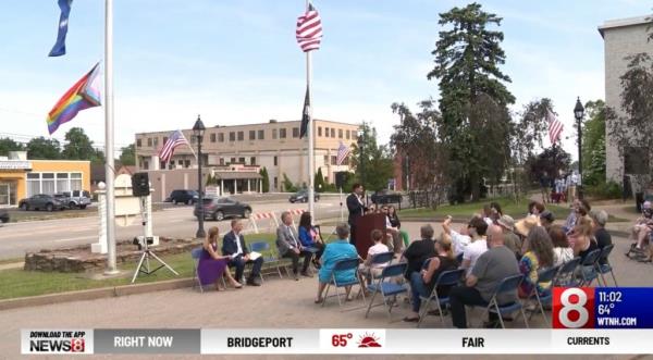 Outdoor meeting wher<em></em>e flags are at half-mast.