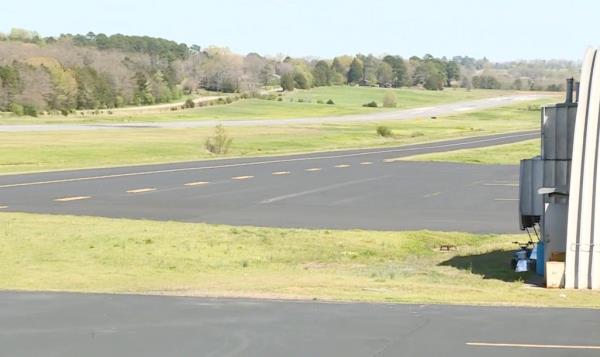 Twin-engine prop plane crashing near Clarksville Municipal Airport during total solar eclipse, with surrounding grass and trees.