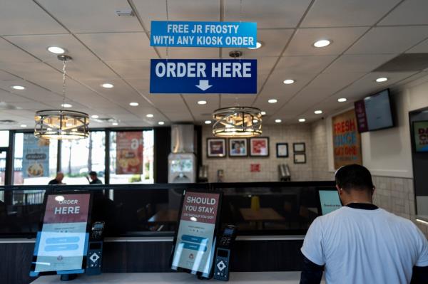 Customer using a self-order kiosk at Wendy's in Fountain Valley, California, after the implementation of $20-an-hour minimum wage law