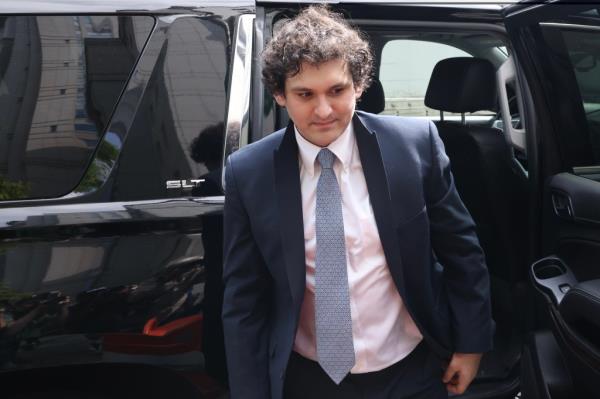 Sam Bankman-Fried, wearing suit, arrives at court in June.