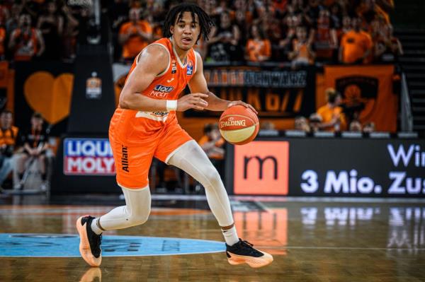 Pacome Dadiet of Ratiopharm Ulm in orange uniform dribbling a basketball during the Basketball Bundesliga Play Off match