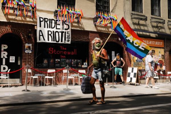 NEW YORK, NEW YORK - JUNE 25: People walk by the Sto<em></em>newall Inn, an ico<em></em>nic bar for the LGBTQ community around the world, on June 25, 2020 in New York City. Along with thousands of other restaurants and bars in New York, the Sto<em></em>newall Inn was forced to close in mid-March as New York City began its long struggle against coronavirus. The bar, which was almost forced to close for good due to the prolo<em></em>nged lockdown, has started a GoFundMe page and has so far exceeded its initial goal of $50,000. (Photo by Spencer Platt/Getty Images)
