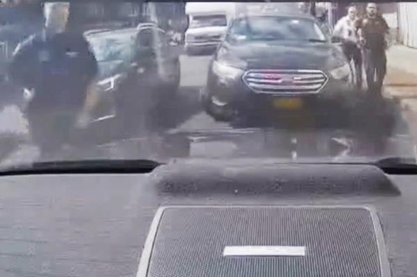 Screenshot of video of cops approaching rear of car 