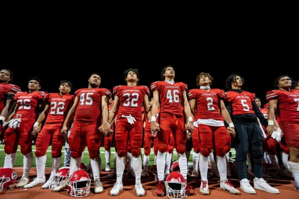 The Lahainaluna High School football team hold hands to thank the fans after a game Saturday, Oct. 21, 2023, in Lahaina, Hawaii.