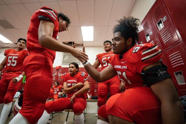 Lahainaluna High School football team players get ready in the locker room at Sue D. Cooley Stadium, Saturday, Oct. 21, 2023, in Lahaina, Hawaii. 