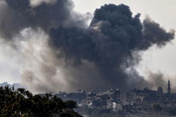 A picture taken from the Israeli side of the border with Gaza shows smoke plumes rising above buildings during an Israeli strike on the Gaza Strip on October 14, 2023. Hamas launched a large-scale attack on Israel on October 7 which killed at least 1300 people, sparking a retaliatory bombing campaign that has killed more than 1900 in the Gaza Strip ahead of a potential Israeli ground invasion of the territory. (Photo by Aris MESSINIS / AFP) (Photo by ARIS MESSINIS/AFP via Getty Images)
