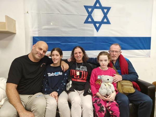 Emily Hand (second from right) reunites with her father, Tom Hand (right) while Hila Rotem (second from left), whose mother is still held hostage, reunites with family members in the early hours of November 26, 2023.