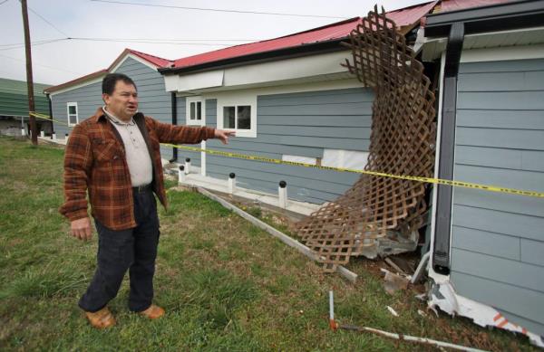The pastor points to the damage.