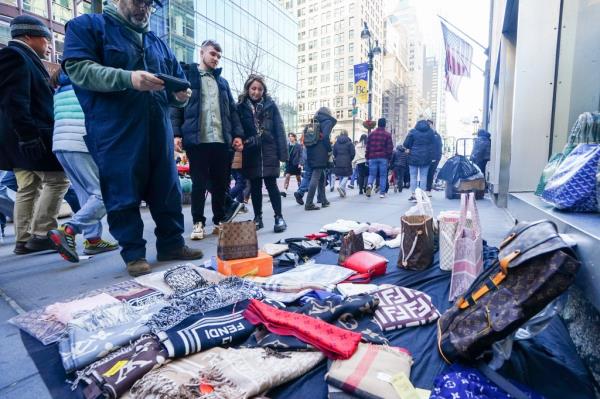 Knockoff Fendi, LV and Goyard bags for sale on a blanket.