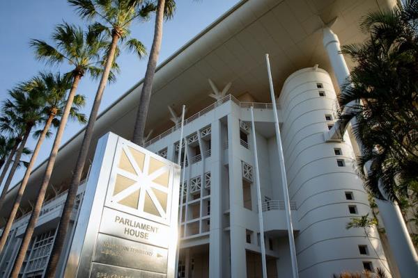 A look up from the ground at the NT Parliament House sign and building in Darwin