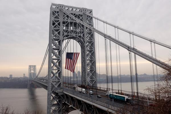 Vehicles cross the George Washington Bridge l<em></em>inking New Jersey to New York City as it displays its 60 by 90 foot American flag to mark President's Day on February 20, 2023, as seen from Ft. Lee, New Jersey.