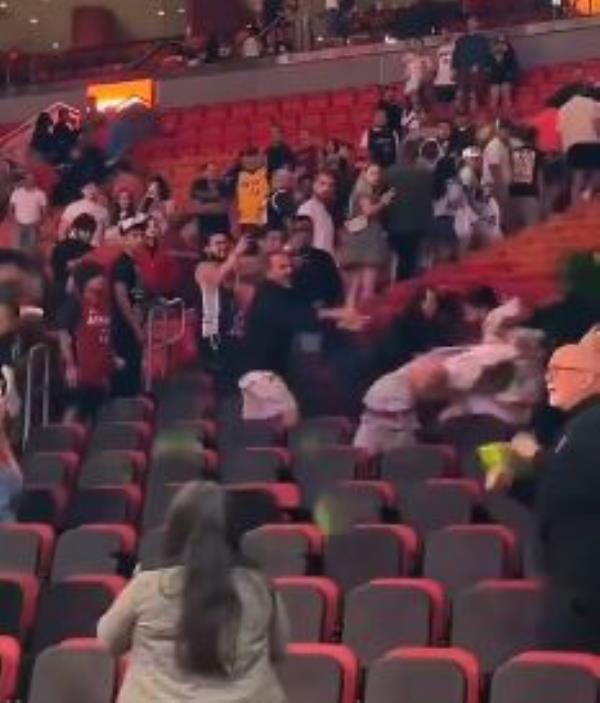 Fans deliver blows during a fight in the stands during the Heat's preseason game on Tuesday.