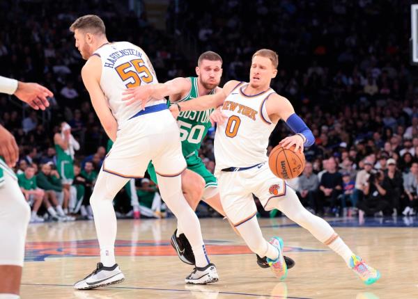 Knicks center Isaiah Hartenstein #55 sets a pick on Boston Celtics guard Svi Mykhailiuk #50 for New York Knicks guard Do<em></em>nte DiVincenzo #0.