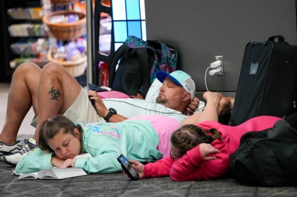 Travelers waiting after expending delays during the Fourth of July holiday chaos.