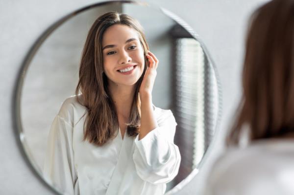 young woman smiling in mirror