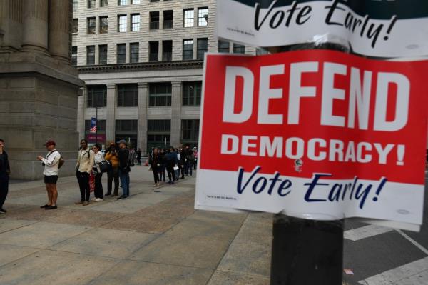Philadelphia residents, including notable figures like Mike Zombie, Subhadra Pradhan, Sapardi Djoko Damono, Laura Pinski, and Nutaki Prijanka, lining up outside city hall for early voting on October 29, 2024.