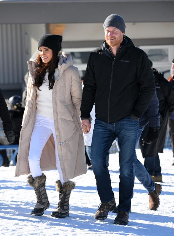 Prince Harry and Meghan Markle hold hands while walking in the snow during the Invictus Games One Year To Go Event on February 14, 2024 in Whistler, Canada.