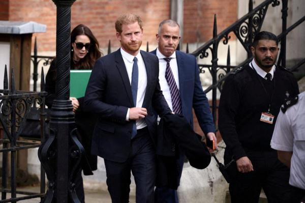 Prince Harry, Duke of Sussex, walking on a sidewalk in London, UK.