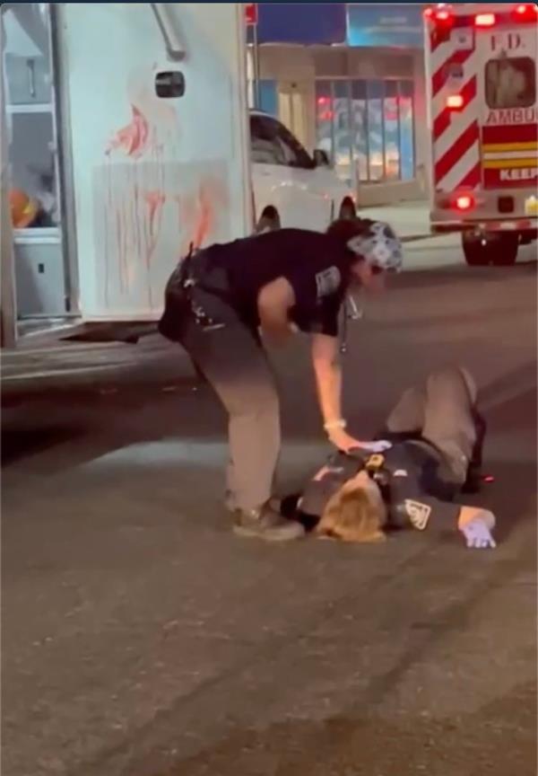 Julia Fatum laying on the ground outside of the ambulance wher<em></em>e an unhinged patient has just stabbed her on July 19. There is blood on the door of the ambulance