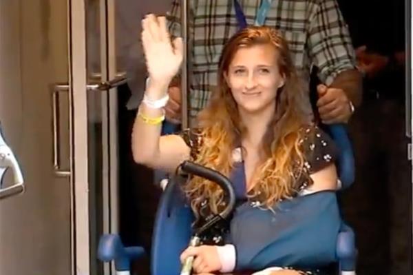 Julia Fatum waving to o<em></em>nlookers as she is rolled out of Mount Sinai in a wheelchair a week after the July 19 attack. 