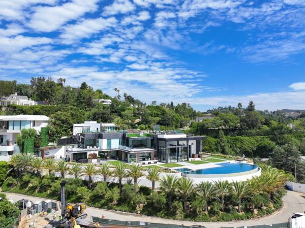 The mansion includes a champagne tasting room, a wine cellar, a suspended glass walkway, a theatre, and an infinity pool overlooking LA.</p>

<p>　　