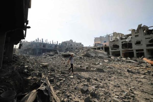 A Palestinian man walks through the rubble in a ravaged neighbourhood in Gaza City early on October 11, 2023, following overnight Israeli airstrikes amid co<em></em>ntinuing battles between Israel and the Hamas movement. The death toll from five days of ferocious fighting between Hamas and Israel rose sharply overnight as Israel kept up its bombardment of Gaza after recovering the dead from the last communities near the border wher<em></em>e Palestinian militants had been holed up. (Photo by Mahmud HAMS / AFP) (Photo by MAHMUD HAMS/AFP via Getty Images)