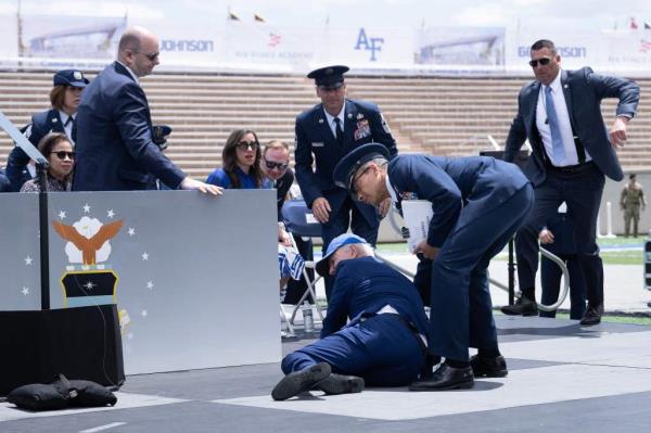 US President Joe Biden is helped up after falling during the graduation ceremony at the United States Air Force Academy, just north of Colorado Springs in El Paso County, Colorado, on June 1, 2023. 