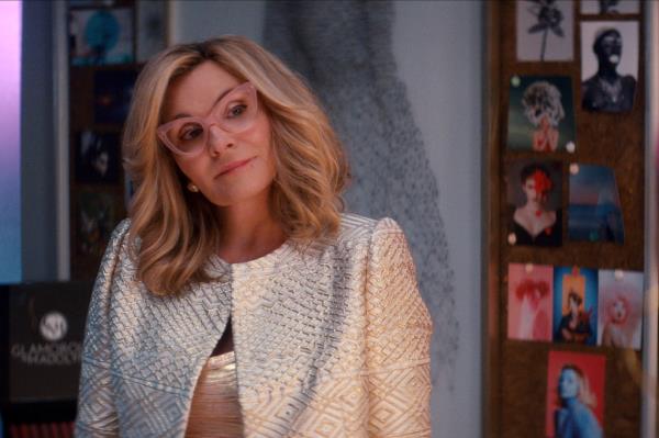 Kim Cattrall in glasses smiling. 
