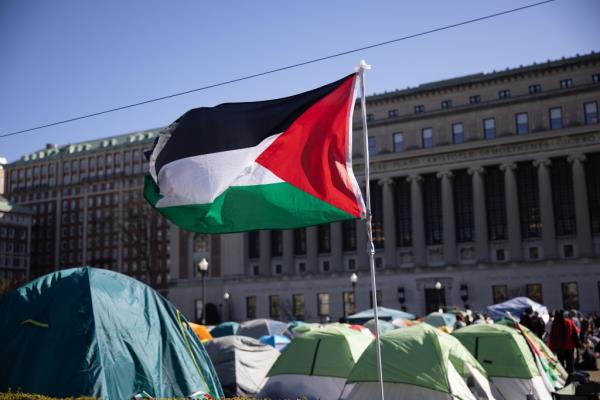 A Palestinian flag waves above the encampment.