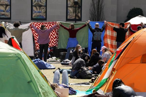A group of students cover the area wher<em></em>e others gathered to pray while taking part in a student protest encampment.