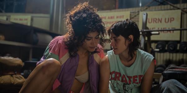 Katy O'Brian and Kristen Stewart lean toward each other in the gym in Love Lies Bleeding