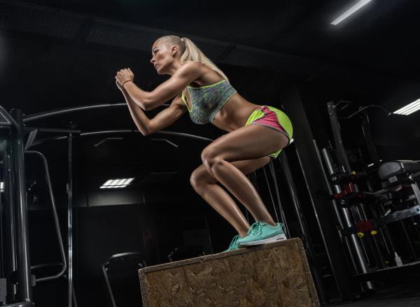 fit woman performing box jumps, co<em></em>ncept of quick HIIT exercises for belly fat
