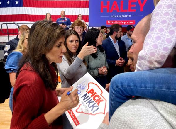 Daniel Schroder, right, holds one of his three children on his shoulders as they wait to meet Republican presidential candidate former UN Ambassador Nikki Haley, left, after a campaign event in Mauldin, South Carolina, on Sunday, Jan. 28, 2024. 